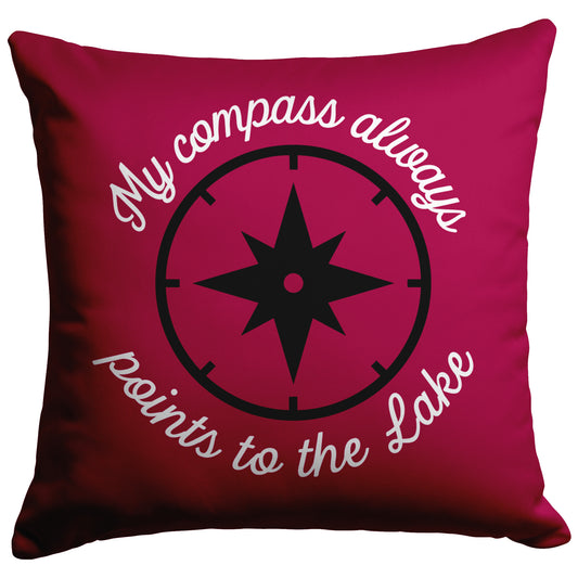 Cranberry pillow with script "My compass always points to the lake" in white around a black compass.